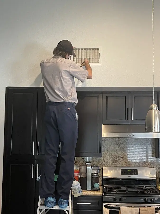 Technician inspecting an air vent during HVAC service in Scotch Plains